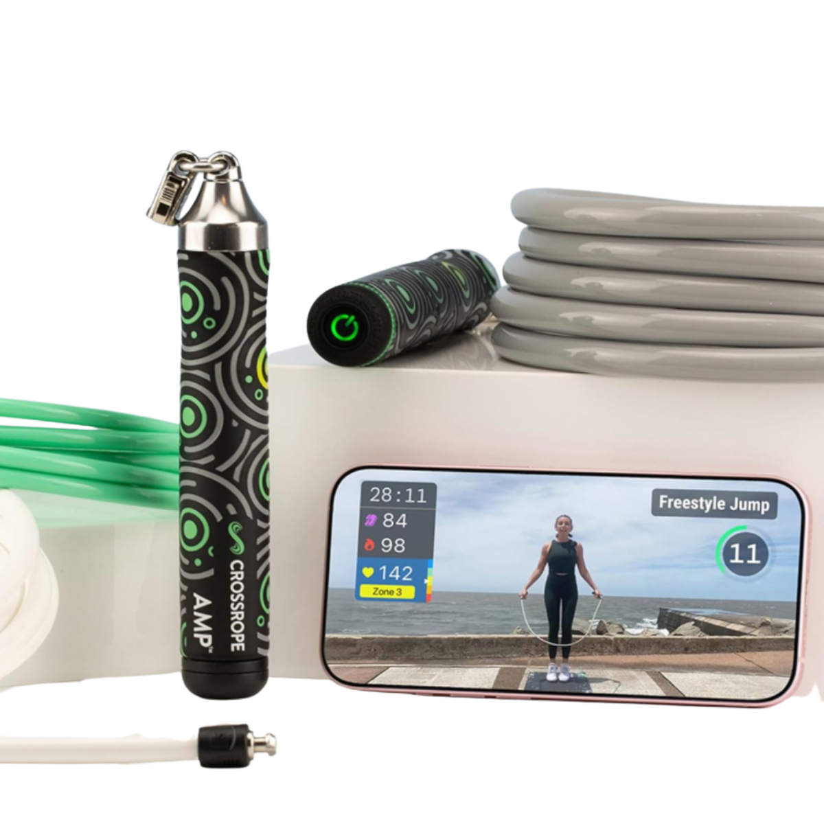 Black and green Crossrope AMP 2.0 smart jump rope handles with gray weighted rope and smartphone workout display, featuring Bluetooth fitness tracking and connected cardio training.