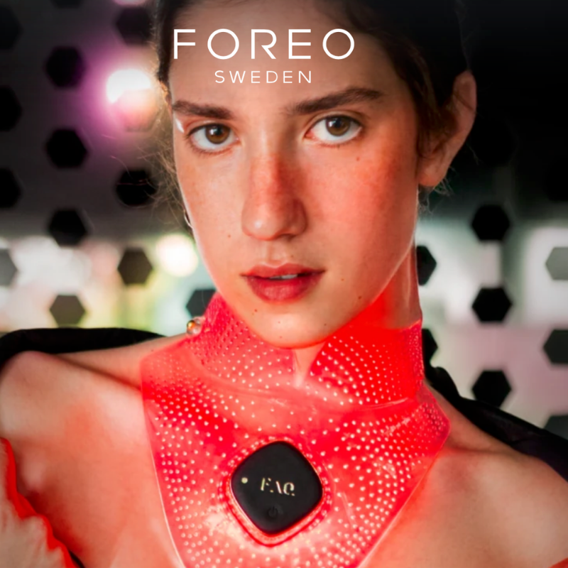 A promotional model wearing the vibrant red glowing Foreo FAQ 211 translucent silicone neck and décolletage mask, highlighting its form-fitting wrap design, dense inner grid of light therapy points, and central diamond-shaped FAQ control module, optimized for targeted collarbone skin rejuvenation.