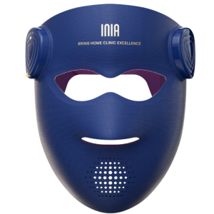 The INIA Glow 4D flexible silicone LED light therapy face mask in navy blue, showing the open eye and mouth design with wireless control modules on the sides.a flexible silicone red light therapy and near-infrared device for advanced facial skin rejuvenation.