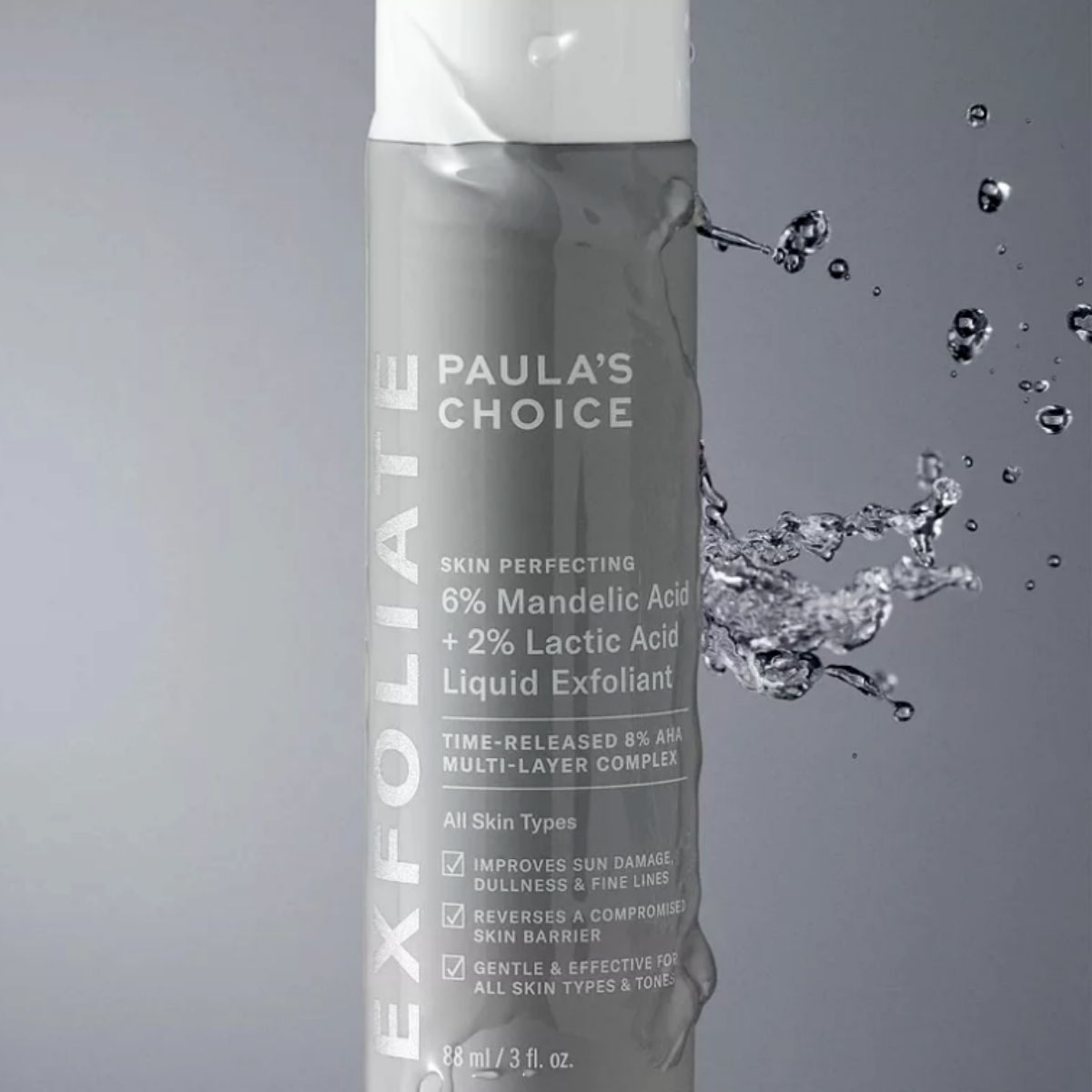 Paula’s Choice Skin Perfecting 6% Mandelic + 2% Lactic Acid Liquid Exfoliant product bottle shown on dark grey background with water droplets, highlighting a gentle AHA liquid exfoliant for resurfacing skin texture and tone.
