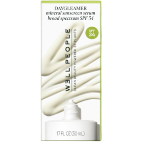 Product shot of a white Well People Daygleamer Mineral Sunscreen Serum tube sitting next to a vertical swirl of its creamy, light-beige sunscreen texture.