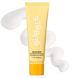 The yellow Bubble Solar Mate sunscreen tube resting vertically over a thick, smooth wave of its white, creamy mineral lotion texture.